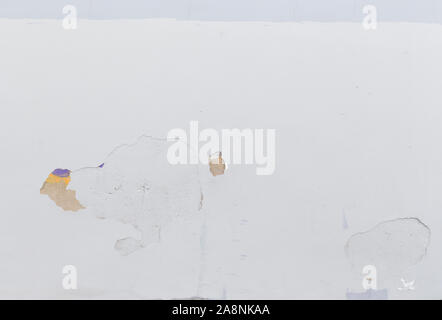 Plastered concrete wall painted in white. Plastering is partly peeled off. High resolution full frame textured background. Copy space. Stock Photo