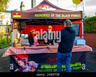 A man buying a sandwich from Gunthers Memories of the Black Forest  selling food  with several varieties of sausage from his stall at a North Yorkshir Stock Photo