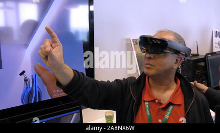 A man interacts with Microsoft HoloLens, a self-contained holographic computer, enabling engagement with digital content and interaction with holograms in the world during Imagine unconference, Haifa, Israel Stock Photo