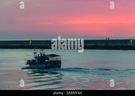 Fishing trawler putting out to sea in Barra near Aveiro Portugal Stock Photo