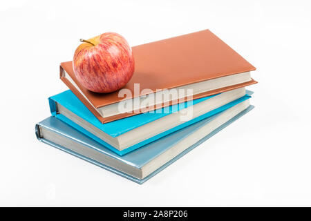 an apple on top of colored books stack - back to school concept. Isolated with clipping path Stock Photo