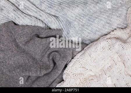 Warm knitted sweaters lying close, top view. Stock Photo