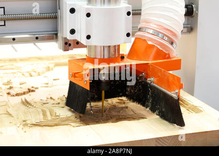 Milling a wooden board. Processing of wood panels on CNC coordinate milling woodworking machines. CNC woodworking machine. Stock Photo