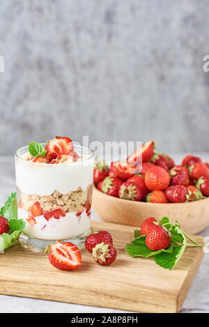 Smoothie with summer strawberry in glass jar and fresh berries  in wooden bowl on gray background Stock Photo