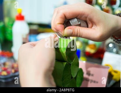 The process of making a toy Christmas tree from paper rings Stock Photo