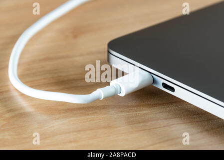 A USB type C cable and USB type C port at a laptop computer. Stock Photo