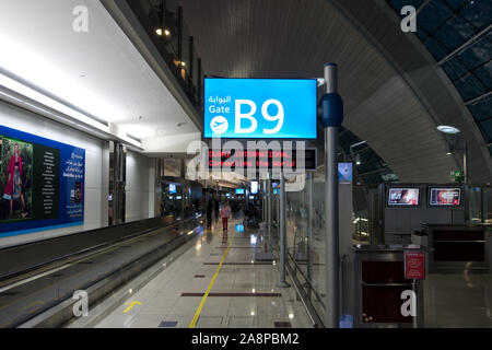 Inside of Dubai International Airport, a blue sign indicates the gate number to departure. Stock Photo