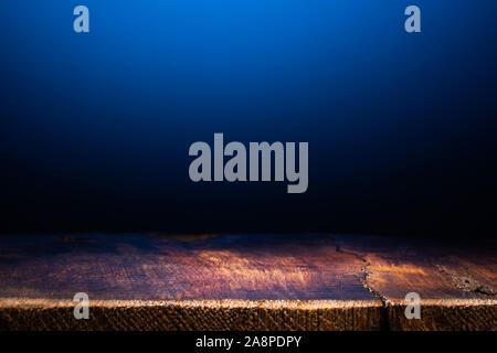 Empty Wooden Table on Dark Blue Background. Backdrop for Product Placement Stock Photo