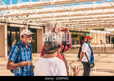 Vers-Pont-du-Gard, Gard / Occitanie / France - September 26, 2018: Age tourists - European pensioners with audio guide