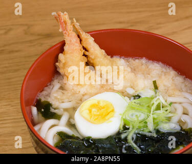 tempura udon with fried shrimps, boiled egg, green algae, leeks, tipical noodles traditional Japanese food Stock Photo