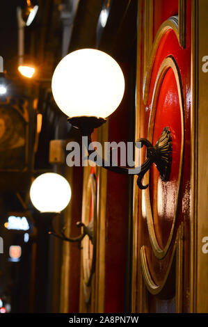 old round lantern ,vintage lamp on the facade in night city street, white led lights Stock Photo