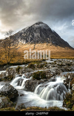 This is a long exposure of a stream and Etive Mor Waterfall  in Glencoe of the Scottish Highlands. Bauchaille mountain can be seen in the distance. Stock Photo