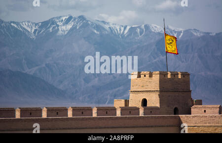 The snowcapped Qilian Mountains behind the ancient fort of Jiayuguan, a part of the Great Wall of China Stock Photo