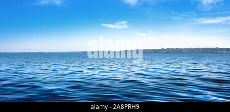 Seascape with sea horizon and almost clear deep blue sky - Background Stock Photo