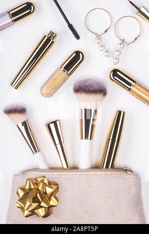 Set of brushes and cosmetic products in a cosmetic bag on a white background. Stock Photo