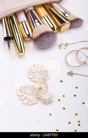Set of brushes and cosmetic products in a cosmetic bag on a white background. Stock Photo