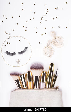 Set of brushes and cosmetic products in a cosmetic bag on a white background. Stock Photo