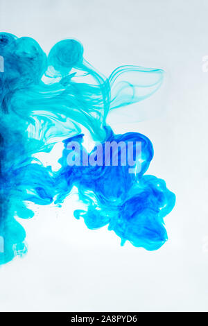Waves of blue ink in water on white background Stock Photo