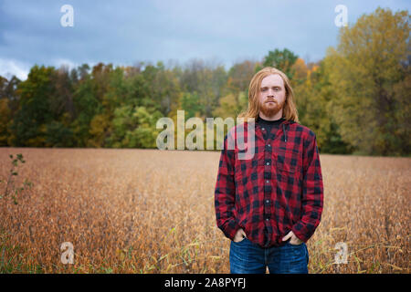 Young Man With Long Red Hair and Beard Outside in the Country Stock Photo