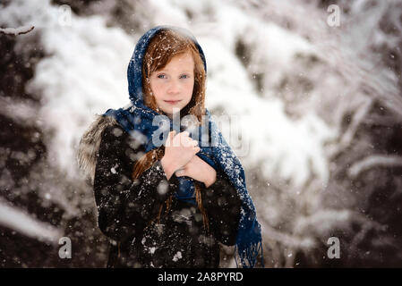 Young Red Haired Girl Playing outside in the Snow Stock Photo