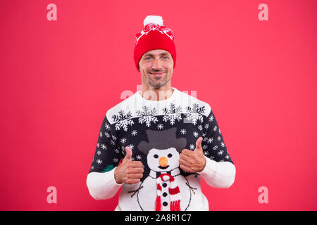 Maintaining sense of style with festive snowman jumper. Happy man give thumbs ups in winter style. Casual comfy style. Fashion trends for winter season. Keep warm in style. Stock Photo