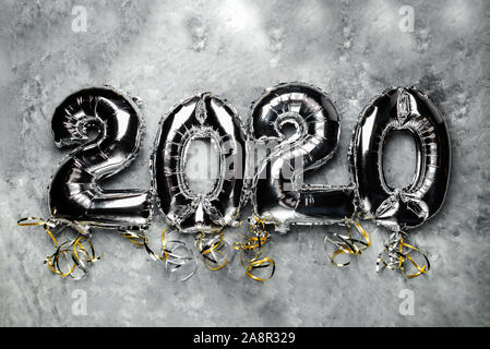 Balloon Bunting for celebration of New Year 2020 made from Silver Number Balloons. Holiday Party Decoration or postcard concept with top view and copy space. Stock Photo