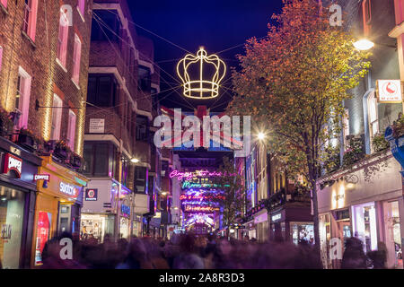 LONDON, UK - 11TH NOVEMBER 2018: Carnaby Street Christmas decorations in 2018. In a Bohemian Rhapsody theme. Lots of people can be seen. Stock Photo