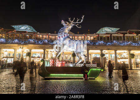LONDON, UK - 17TH NOVEMBER 2018: A large decorated reindeer at Covent Garden in London at night. People can be seen. Stock Photo