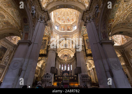 Architectural image of the ceiling inside Bergamo cathedral, with many paintings visible on the walls. Stock Photo