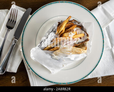 From above view of wrapped chicken souvlaki gryo takeout food plated at home with napkin Stock Photo