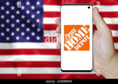 Logo of public company Home Depot displayed on a smartphone. Flag of USA background. Credit: PIXDUCE Stock Photo