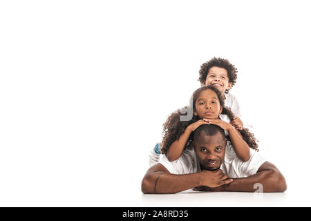 african american daughter and son having fun while lying on fathers back together on white background Stock Photo