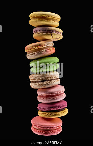 stack of delicious fresh French macaroons of different flavors isolated on black Stock Photo