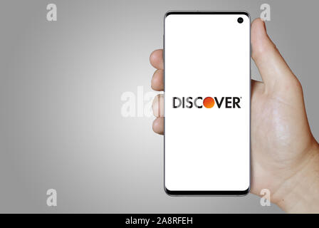 Logo of public company Discover Financial Services displayed on a smartphone. Grey background. Credit: PIXDUCE Stock Photo