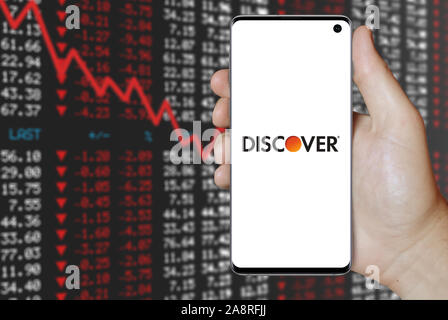 Logo of public company Discover Financial Services displayed on a smartphone. Negative stock market background. Credit: PIXDUCE Stock Photo