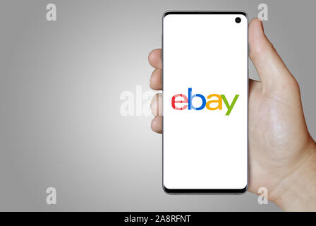 Logo of public company eBay Inc. displayed on a smartphone. Grey background. Credit: PIXDUCE Stock Photo