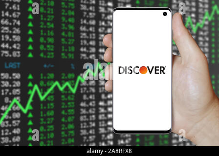 Logo of public company Discover Financial Services displayed on a smartphone. Positive stock market background. Credit: PIXDUCE Stock Photo