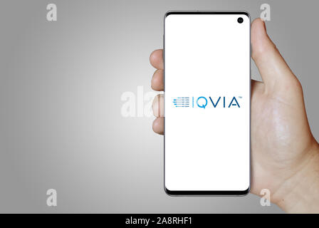 Logo of public company IQVIA Holdings Inc. displayed on a smartphone. Grey background. Credit: PIXDUCE Stock Photo