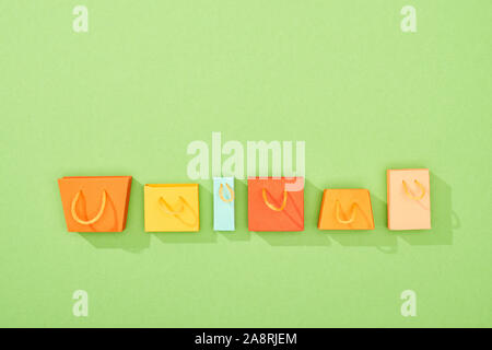 top view of decorative colorful shopping bags on green background Stock Photo