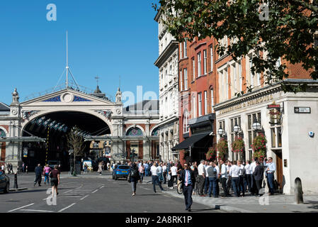 People drinking outside Fullers Ale & Pie House pub or public house with market building in background West Smithfield, City of London Stock Photo