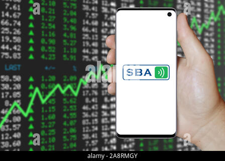 Logo of public company SBA Communications displayed on a smartphone. Positive stock market background. Credit: PIXDUCE Stock Photo