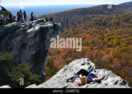 Visitors crowd dangerously to the edge of the overlook to view the Fall colors and take photos at Hanging Rock State Park outside Danbury, NC. Stock Photo