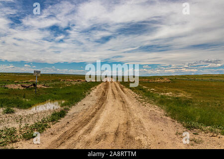 A dirt road leads through open range territory in Wyoming near the Laramie Mountains. Stock Photo