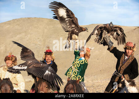 A group of traditional kazakh eagle hunters holding their golden eagles on horseback. Ulgii, Mongolia. Stock Photo