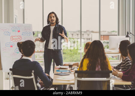 Asian Creative manager man presenting the successful ideas in front of Group Of Asian Business people with casual suit in serious action in the modern Stock Photo
