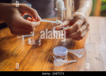 Travel kit for transporting cosmetics on an airplane. Cosmetics are ready to be poured into small bottles. A woman shifts cosmetics to take with her Stock Photo