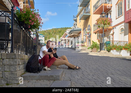 MONT-TREMBLANT, QUEBEC, CANADA, - SEPTEMBER 13, 2018: Mont-Tremblant ski resort, tourists at the main entrance, European view is a year-round ski reso Stock Photo