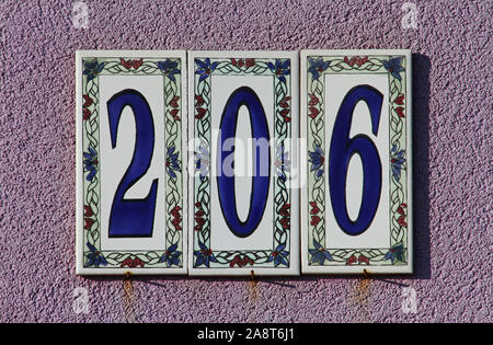 decorative majolica ceramic tiles giving a house number on a street in a fishing village called Porto Recanati on the Adriatic coast in central Italy Stock Photo