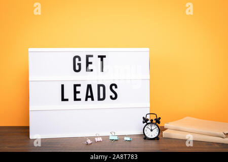 Get leads. Business concept. White lightbox on a wooden table. Stock Photo