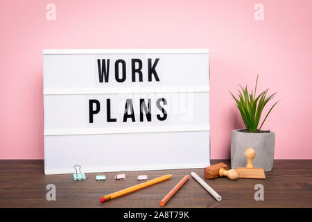 Work plans. Business, team, meeting and brainstorming concept. White lightbox on a wooden table Stock Photo